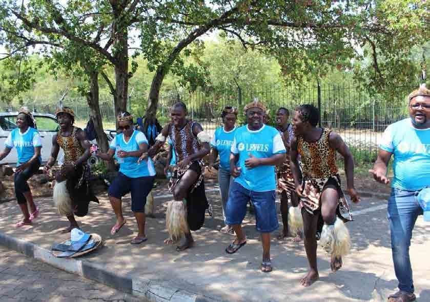 Outdoor team celebration with people dancing in blue shirts.
