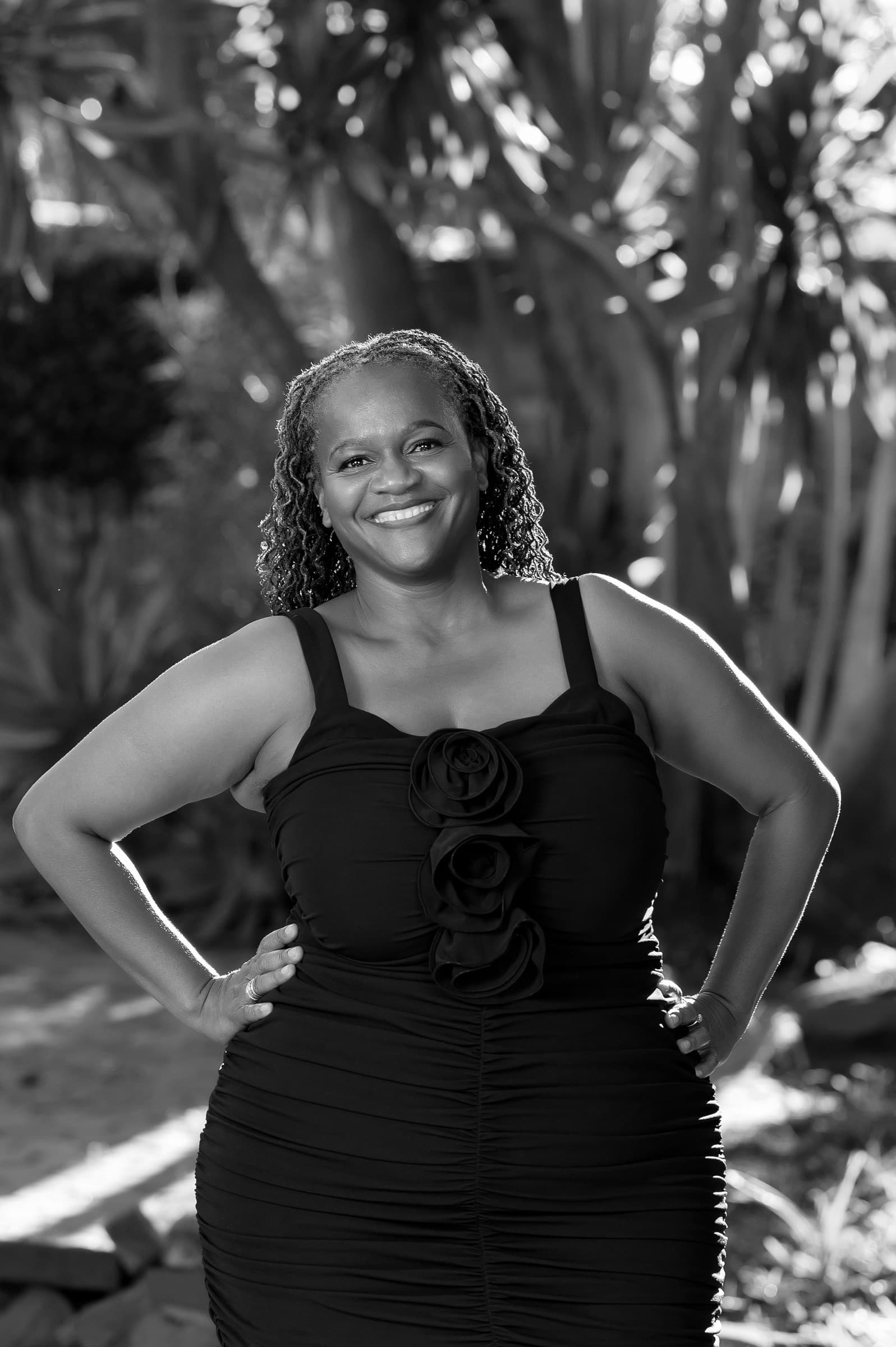 Clara Mlambo in a black dress garden portrait.