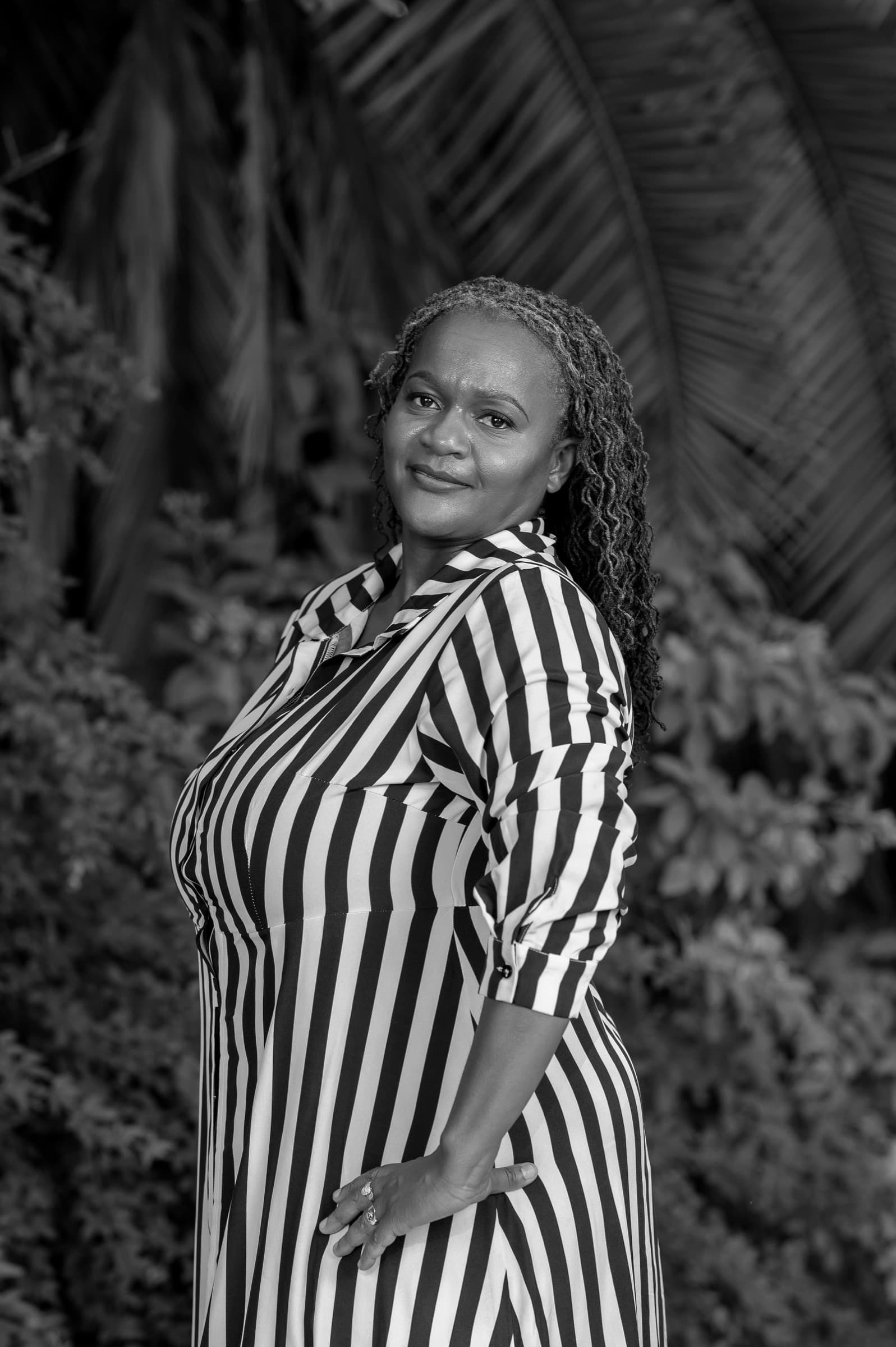 Clara Mlambo in a striped dress garden portrait.
