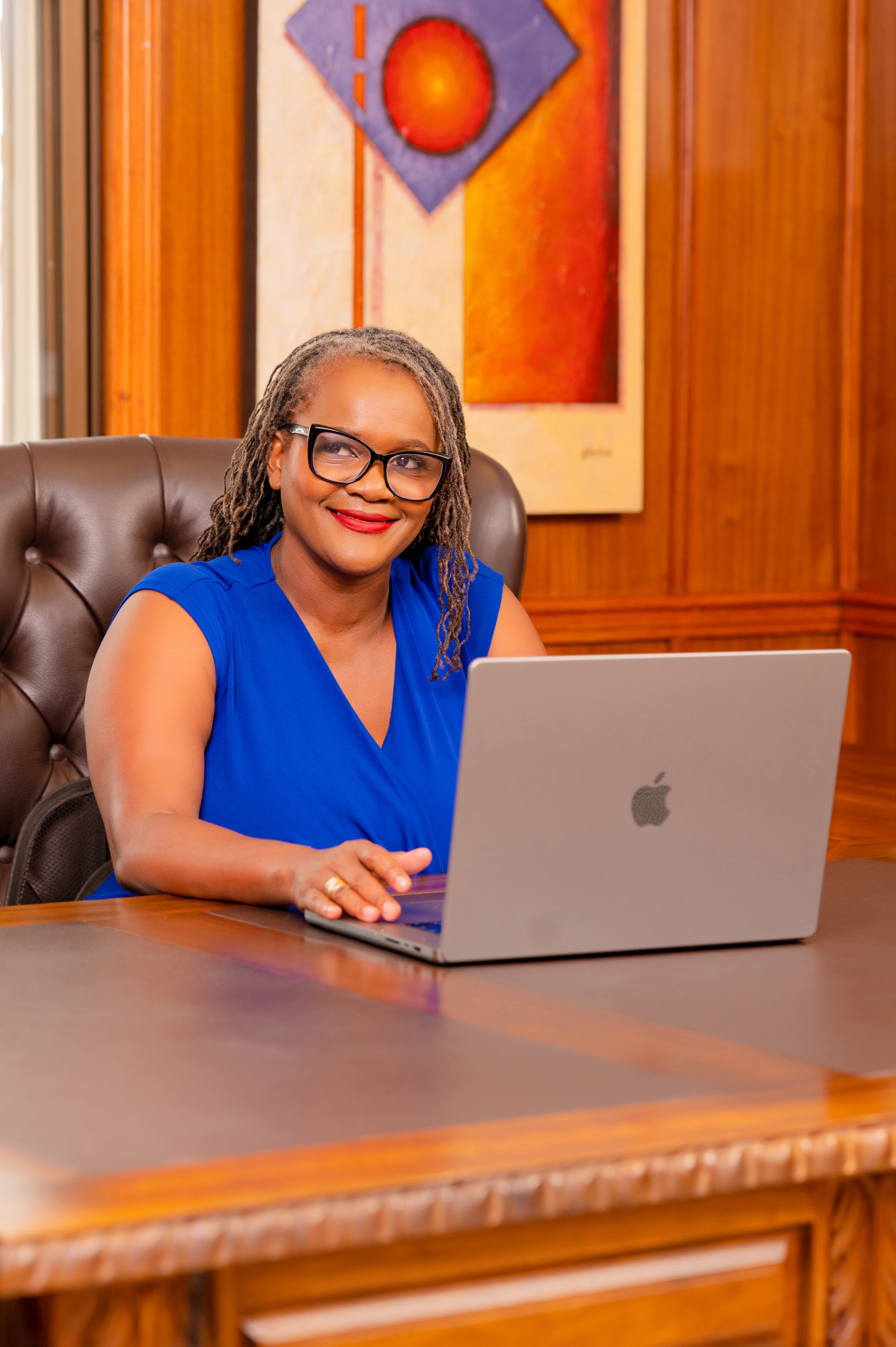 Clara Mlambo seated at a laptop in an office portrait.