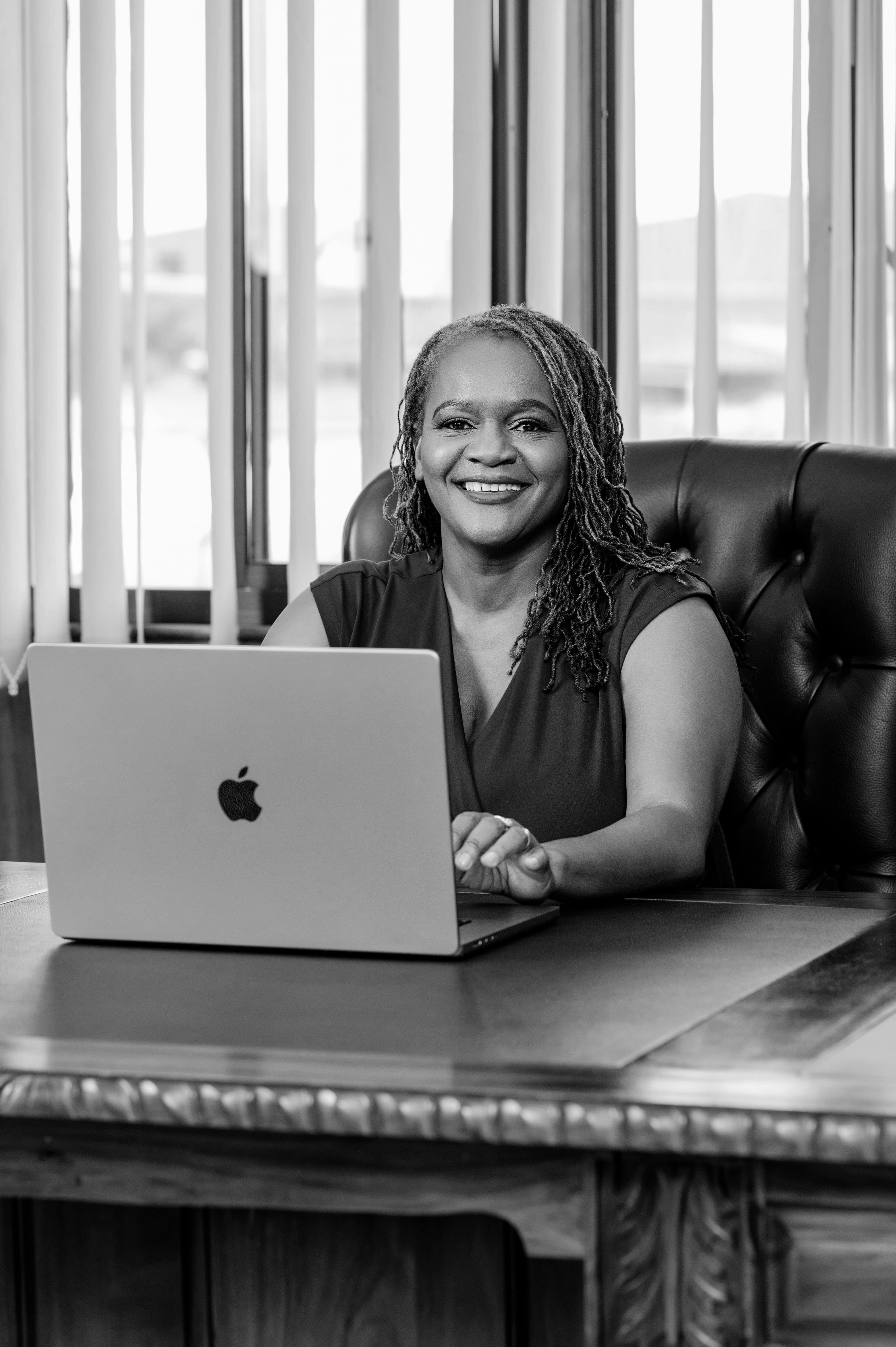 Clara Mlambo seated at a laptop in an office portrait.